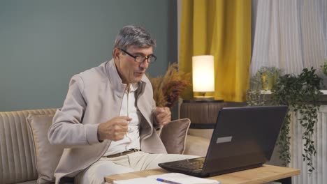 Old-man-looking-at-laptop-is-happy-and-dancing.